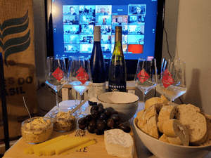Online Weinprobe zuhause im Wohnzimmer mit mit Käse und Brot