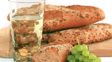 Weißweinschorle in Dubbeglas mit Brot